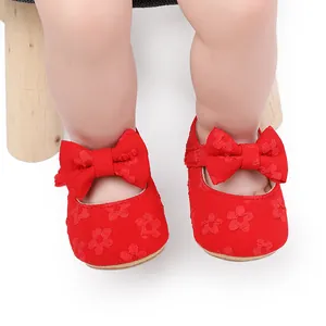 Primer plano de zapatos de princesa rojos de encaje para bebé con lazos decorativos grandes