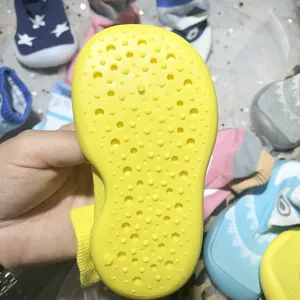 Detailansicht der gelben rutschfesten Gummisohle von Baby-Bodensocken-Schuhen