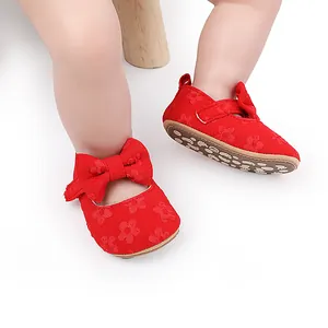 Primer plano de zapatos de princesa para bebé en encaje rojo con lazo y suela suave antideslizante