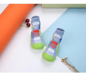 Detailed view of baby sock shoes featuring colorful jellyfish patterns and non-slip green soles.