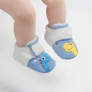 Detail van zachte pluche winter baby wandelschoenen met schattig dinosaurus design