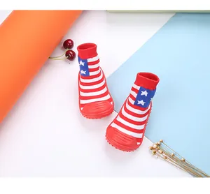 Close-up of baby walker socks shoes with star and stripe pattern and red rubber soles.