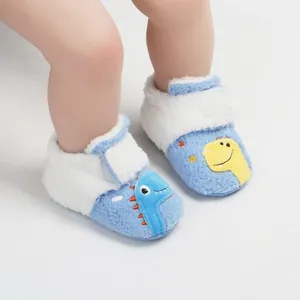 Close-up van zachte pluche baby winterslofjes met schattig dinosaurus borduursel