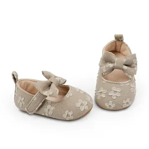 Detalle del bordado floral y el lazo en zapatos Mary Jane beige para bebé niña