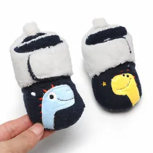 Detailweergave van pluche baby-winterschoentjes met schattig blauw dinosaurusborduurwerk