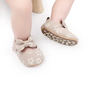 Primer plano de zapatos de princesa para bebé en encaje beige con lazo y suela antideslizante