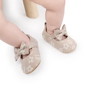Primer plano de zapatos de encaje beige para bebé niña con elegante detalle de lazo