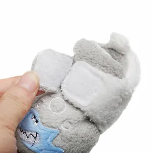 Detailopname van witte klittenbandsluitingen op pluche grijze haaien baby winterschoenen
