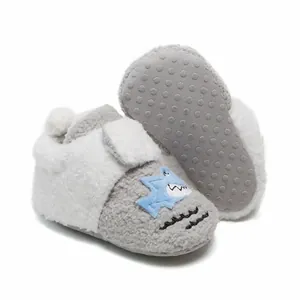 Detailweergave van pluche baby winterschoentjes met haaienmotief en een antislipzool