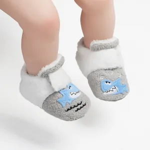 Gedetailleerd overzicht van pluchen babyloopschoentjes met een schattige blauwe haai