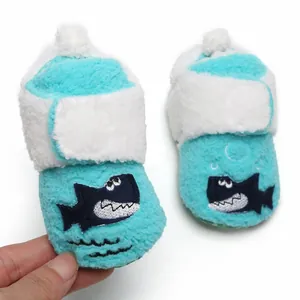 Detailopname van blauwe zachte baby winterslofjes met schattig haaienborduursel