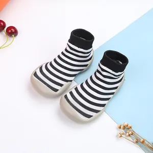 Zapatos calcetín para bebé a rayas blancas y negras con suelas de goma gris antideslizantes
