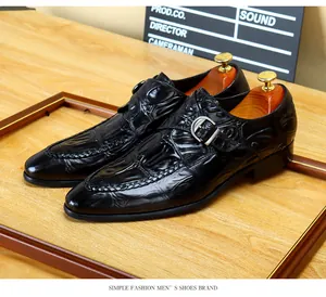 Dettaglio di scarpe da uomo in pelle nera con motivo a coccodrillo e fibbia