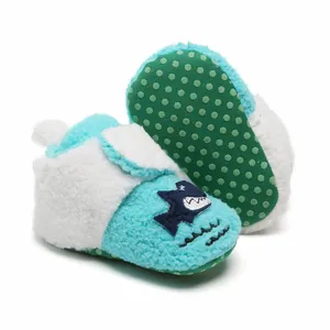 Detailweergave van pluche babyloopschoentjes met een antislip groen gestippelde zool.