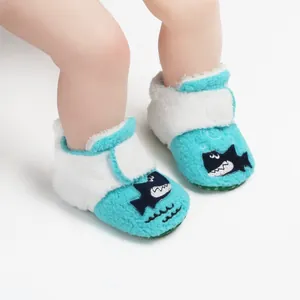Detailweergave van pluchen winter babyschoentjes met blauw haaienpatroon en klittenband