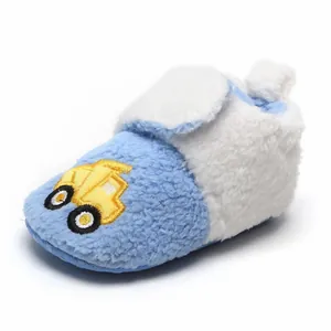 Gedetailleerd overzicht van de blauwe pluche babyschoen met geel auto borduursel