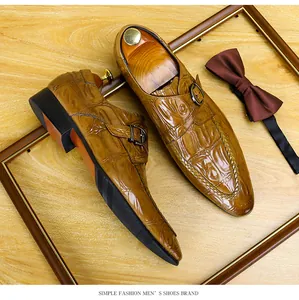 Dettaglio di scarpe da lavoro da uomo in pelle con motivo a coccodrillo e fibbia