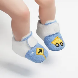 Gedetailleerde close-up van de blauw-witte pluche winterbabyschoenen aan babyvoetjes