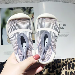 Close-up of baby walking sock shoes with plaid pattern and soft anti-slip rubber soles