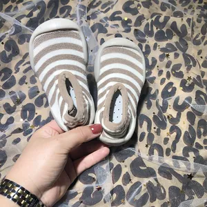 Detailed close-up of breathable striped baby walking sock shoes with anti-slip soft rubber soles