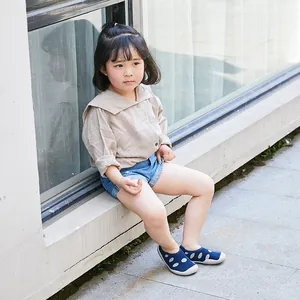 Toddler wearing blue polka dot breathable soft sole sock shoes in an outdoor setting