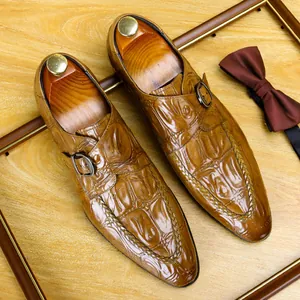 Eleganti scarpe da uomo marroni in pelle con motivo a coccodrillo e fibbia monk strap.