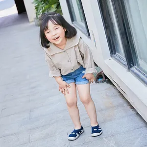 Close-up of breathable navy blue polka dot sock shoes worn by a child in an outdoor setting