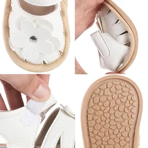 Soft-sole white baby walker shoes with floral detail and anti-slip pebble texture.