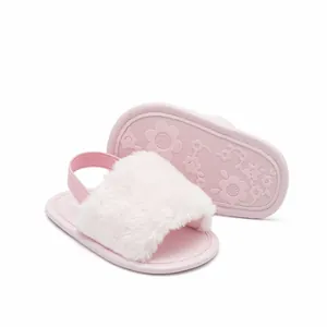 Close-up of pink furry baby sandals showing soft faux fur and flower patterned sole