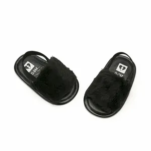 Detail view of black fuzzy infant sandals with elastic backstrap and 0-6M insole mark