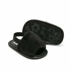 Close-up of black furry baby sandals with soft elastic strap and floral grip sole