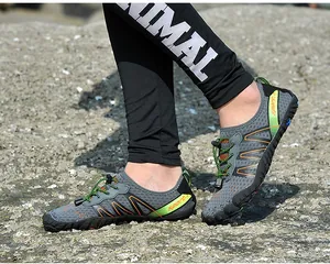 Close-up detail of breathable quick-dry outdoor water shoes worn on a rocky beach shore