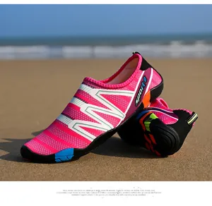 Pink patterned quick-dry water shoes for swimming and beach activities on sandy background