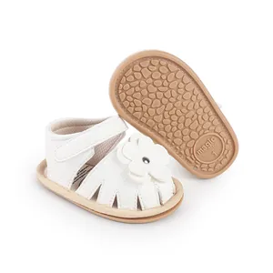 Close-up of white baby prewalker sandals with flower detail and non-slip rubber sole.
