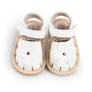 Detail top view of white baby walker sandals featuring leather flowers and soft soles.
