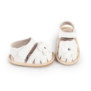 Detailed view of white leather-like baby prewalker sandals with cute flower detail