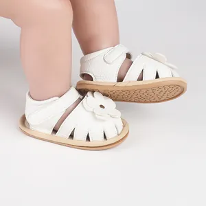 Close-up of white baby walker sandals with floral detail and non-slip soles
