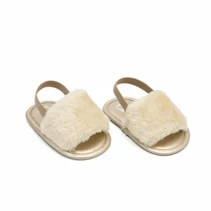 Pair of fluffy beige baby sandals with elastic back strap on white background