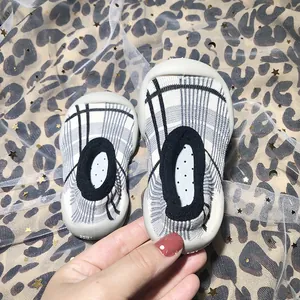 Close-up detail of infant checkered pattern sock shoes featuring flexible soft anti-slip soles