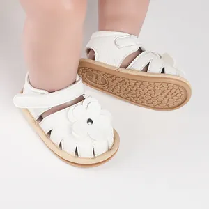 Close-up of white baby walker sandals with flower decoration and textured sole