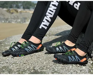 Close-up of quick-dry water shoes on rocky beach with green elastic laces