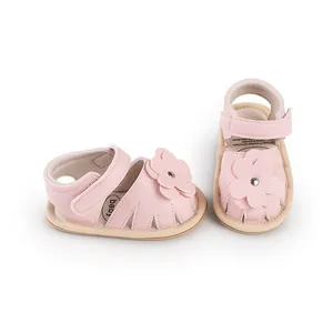 Soft pink baby walking sandals featuring floral applique and adjustable velcro straps