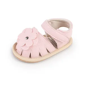 Detail shot of pink baby walker shoes featuring a cute flower and soft leather texture