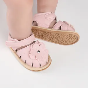 Detail view of pink infant walking shoes with flower decoration and non-slip sole.