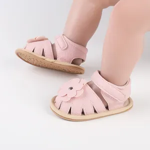 Close-up of pink soft-sole baby walker sandals with flower detail and velcro strap.