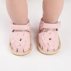 Detailed view of pink baby walking shoes with cute flower decoration and soft leather