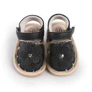 Detailed view of baby first walker sandals with black leather flower accent