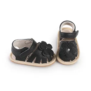 Close-up detail of black prewalker baby sandals featuring 3D flower decoration on a white background