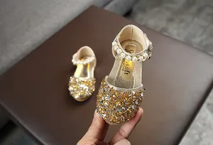 Detailansicht goldener Pailletten-Prinzessinnenschuhe für Mädchen mit Perlenriemen.