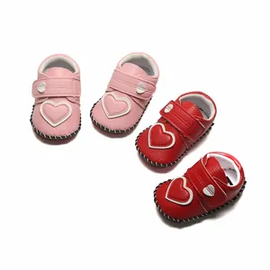 Détails des chaussures de marche souples pour bébé en rose et rouge avec cœurs.